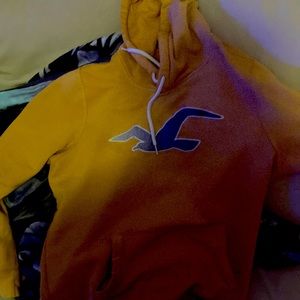 Black ripped jeans cowboy boots a orange hoodie and a belt